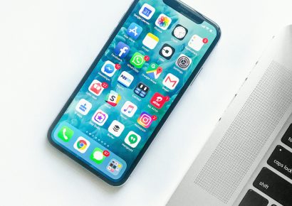 Unlocked iPhone on the table, next to a laptop.