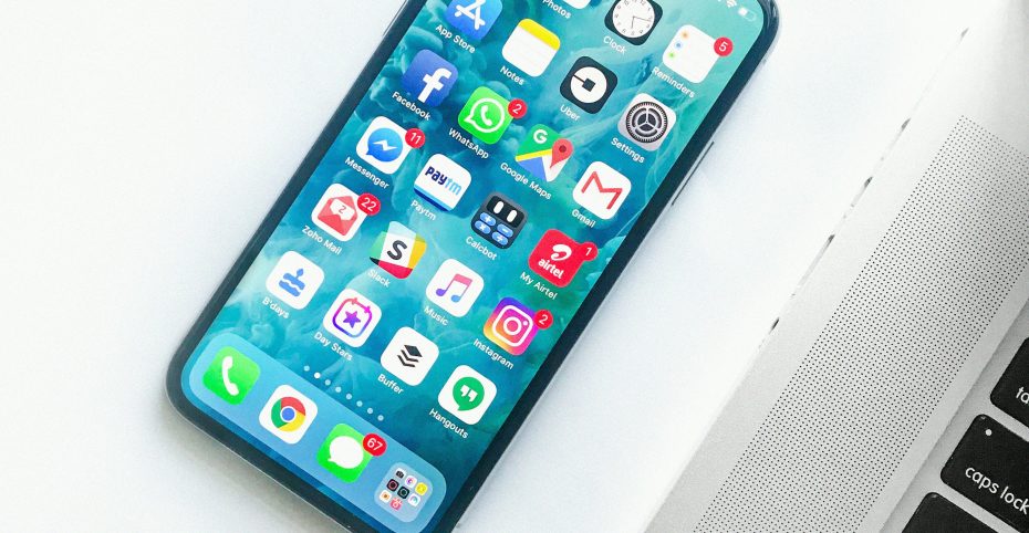 Unlocked iPhone on the table, next to a laptop.
