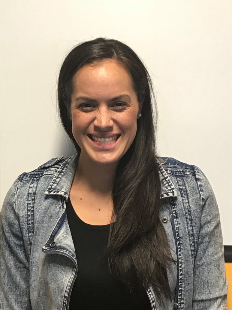 Hailey Moala, she has long dark hair pulled to one side. She is wearing a denim jacket and black top under.