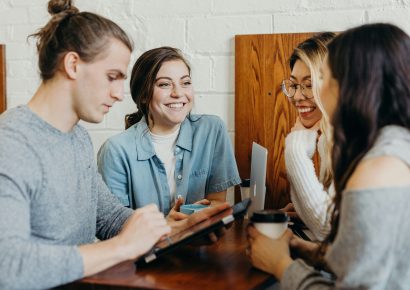 A group of people chatting around a table and smiling