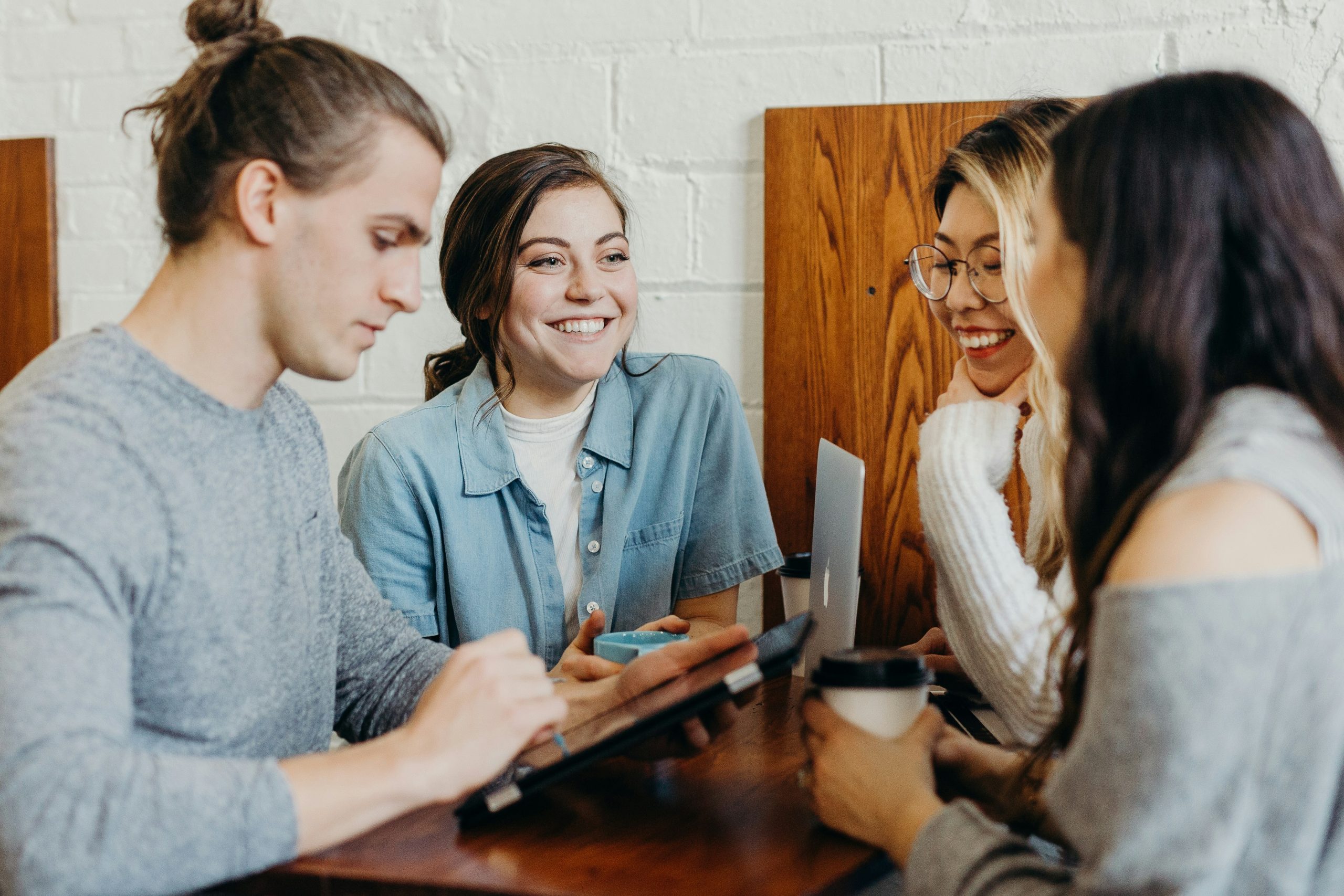 A group of people chatting around a table and smiling