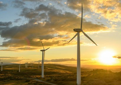 Windmills on hills at sunset with clouds