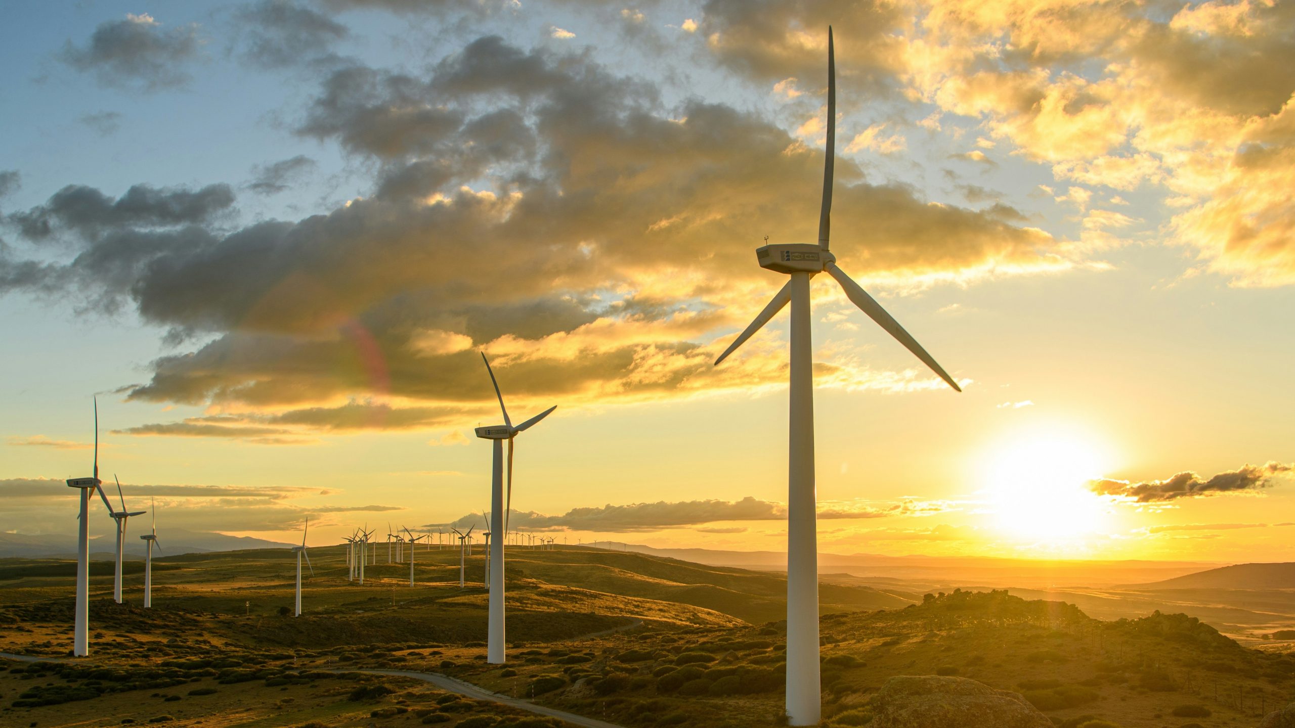 Windmills on hills at sunset with clouds