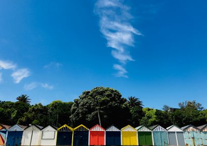Row of boat sheds in Porirua with blue skies above