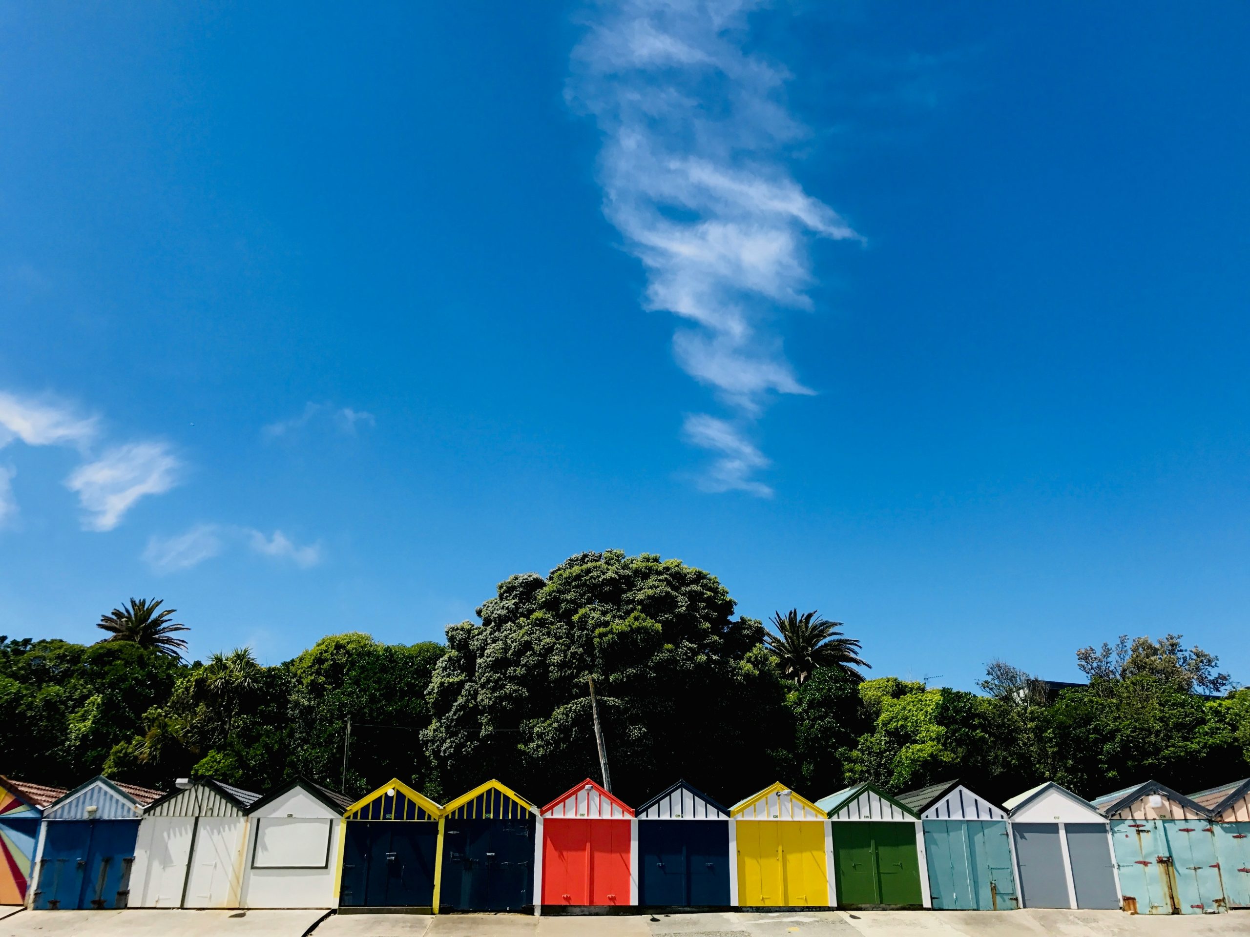 Row of boat sheds in Porirua with blue skies above